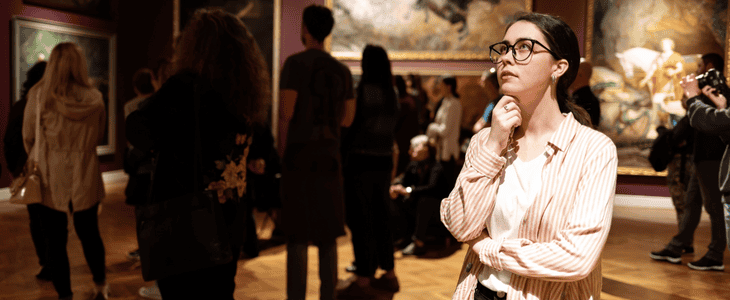 An art enthusiast ponders while attending an art gallery